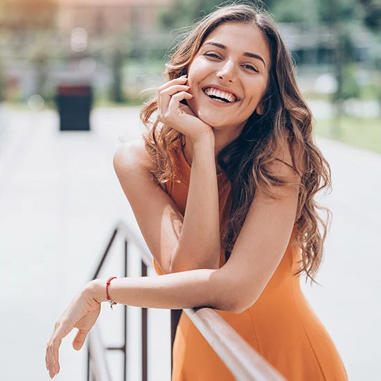 Glückliche Frau in orangem Kleid