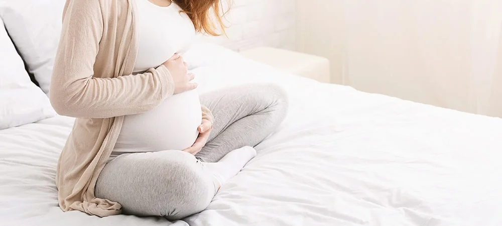 Schwangere Frau hält ihren Bauch