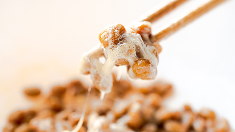 Nahaufnahme von fermentiertem Natto (Nattokinase) auf Essstäbchen